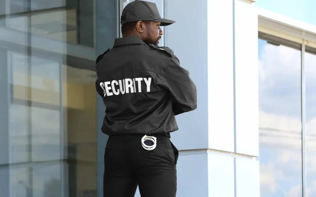 Security officer standing guard outside a glass-fronted office building